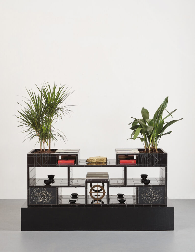 Rashid Johnson b. 1977, United States A Place for Black Moses, 2010 Black ceramic tile, black soap, wax, books, vinyl in album cover, brass, shea butter, space rock, star scapes, plants, and stained wood 39 1⁄4 × 78 1⁄2 × 30 5⁄8 inches